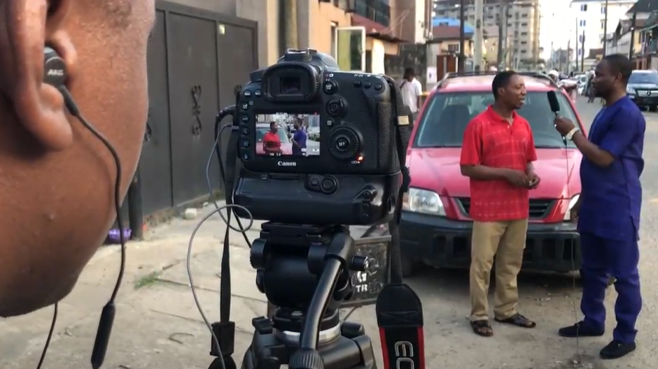 Filming an interview with a man on the streets of Nigeria.