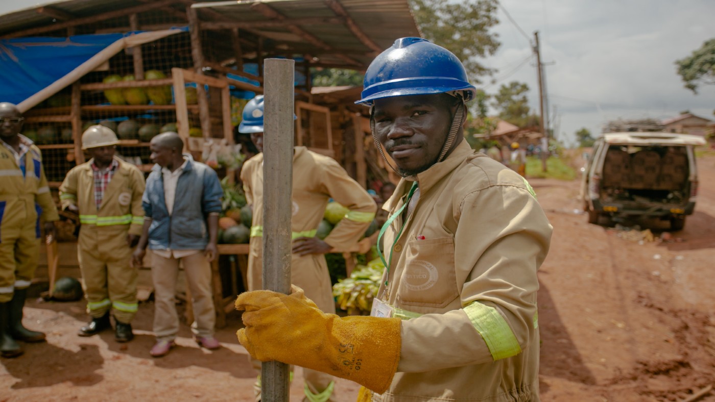 A man wearing a hard hat and overalls, looking at the camera.