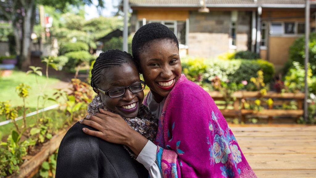 Two women smiling and hugging in Kenya.