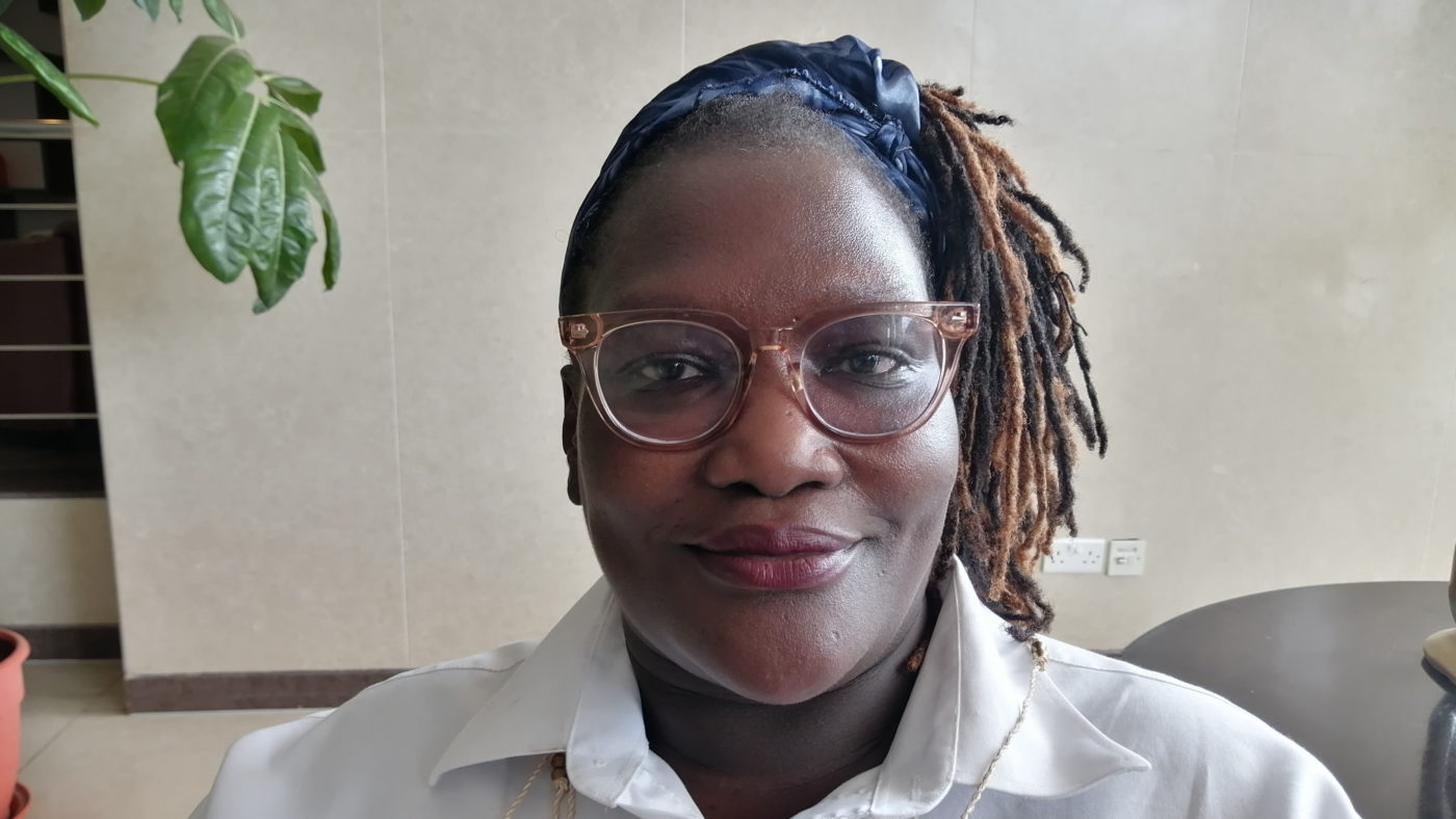 A head and shoulders photo of Easter Okech, wearing glasses with her hair in a ponytail.