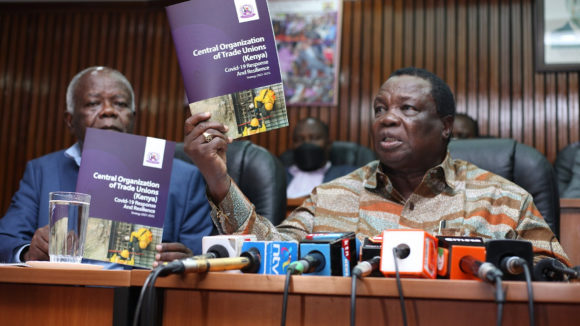 The Secretary General of COTU-K, Francis Atwoli at a press conference holding a strategy document with the title Covid-19 response and resilience (2021-25)