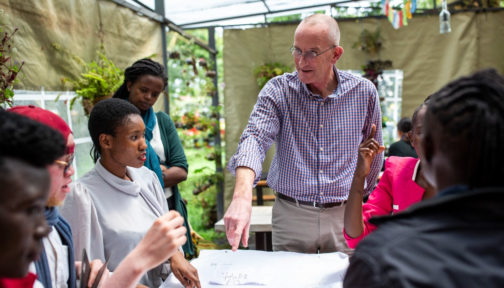 A white man in a stripy shirt participates with job seekers with disabilities in a research session in Nairobi, Kenya.
