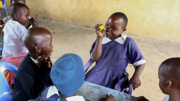 A girl with a disability interacts with children without disabilities in her class.