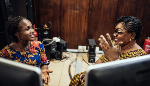 Onyinyechi, who is a polio survivor and information analyst, sits next to her colleague Agiri at the Nigeria civil service commission.
